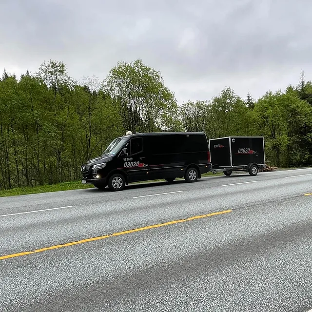 Sort varebil med tilhenger